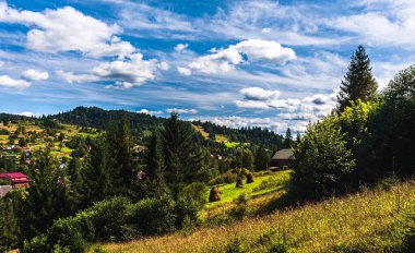 Karpatlar 'da dağlar ve bulutlu gökyüzü. Dağ manzarası. Samanlıklar. Ormanlar dağlarda yetişir. Boşluğu kopyala.