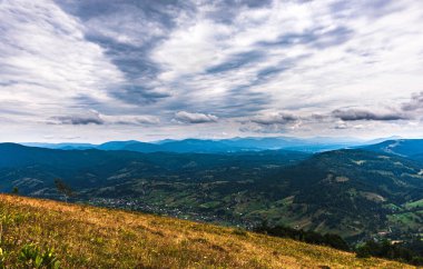 Karpatlar 'da yaz günü. Dağ manzarası. Ormanlar dağların yamaçlarında yetişir. Bulutlu güzel bir gökyüzü. Boşluğu kopyala