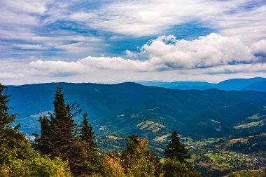 Ukrayna Karpatları. Dağ manzaralı. Ormanlar dağların yamaçlarında yetişir. Bulutlu güzel bir gökyüzü. Boşluğu kopyala.