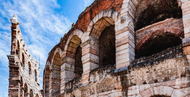 Italy.Verona. Arena di Verona 'nın bir parçası beyaz bulutlu mavi gökyüzünün arka planına karşı. Boşluğu kopyala.