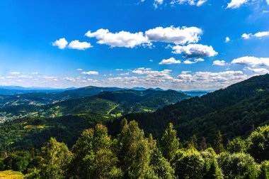 Karpatlar 'da yaz günü. Dağ manzarası. Ormanlar dağların yamaçlarında yetişir. Bulutlu güzel bir gökyüzü. Boşluğu kopyala.