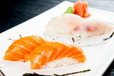 Beyaz tabakta somonlu nigiri.