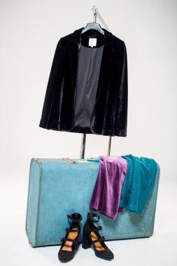 Klasik bavul, siyah ayakkabı ve mor elbise.
