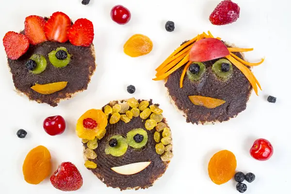 Funny faces toasts with spread chocolate and dates and fruit