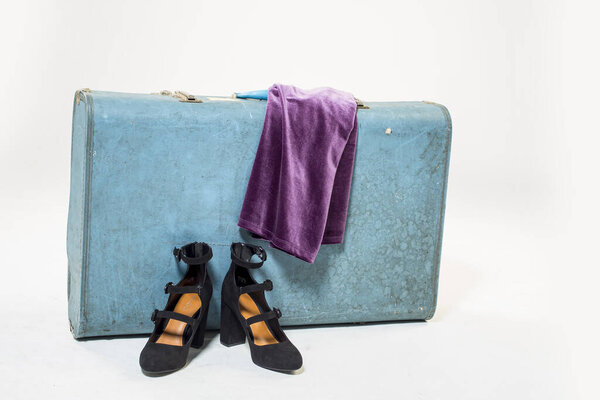 Винтажный чемодан, черная обувь и фиолетовое платье