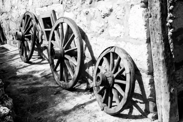 old wood coach wheels, black and white photo