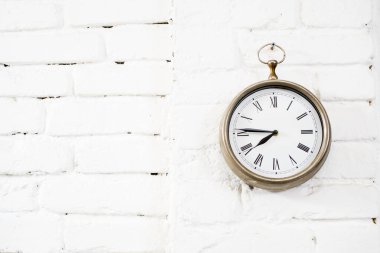 Büyük bir cep saati. Beyaz duvardaki metal saat