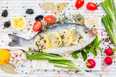 Limonlu taze çiğ solungaç balıklar, otlar, tahta tahtada tuz, beyaz ahşap arka plan. Sağlıklı gıda konsepti. Yiyecek çerçevesi. Balık gübresi.