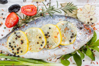 Limonlu taze çiğ solungaç balıklar, otlar, tahta tahtada tuz, beyaz ahşap arka plan. Sağlıklı gıda konsepti. Yiyecek çerçevesi. Balık gübresi.