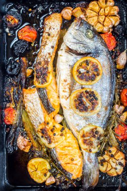 Sebze ve baharatlı siyah tavada balık ve somon.