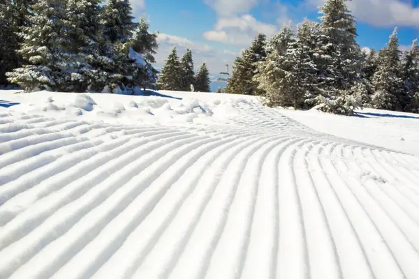 Snow lines made from a snow machine on a ski slope