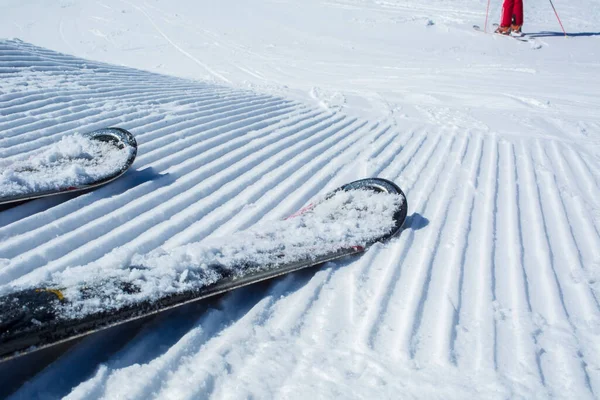 Snow lines made from a snow machine on a ski slope with skis
