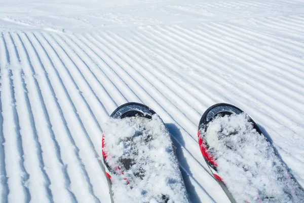 Snow lines made from a snow machine on a ski slope with skis