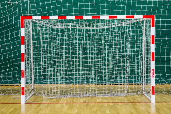 Futbol kalesinde kırmızı ve beyaz kale direği salonda.
