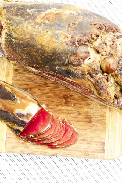 Jamon serrano. Beyaz ahşap bir güvertede İspanyol jambonu. Tütsülenmiş domuz