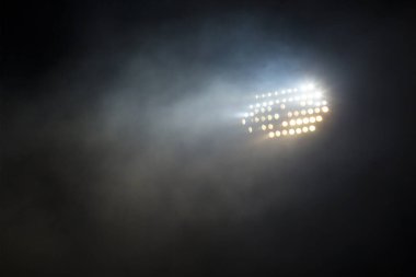 Light tower lit at a stadium during nightime. clipart