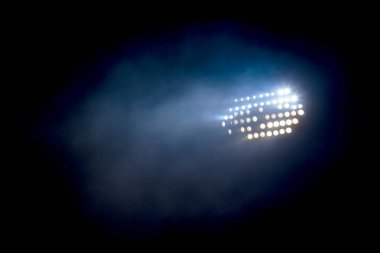 Light tower lit at a stadium during nightime. clipart