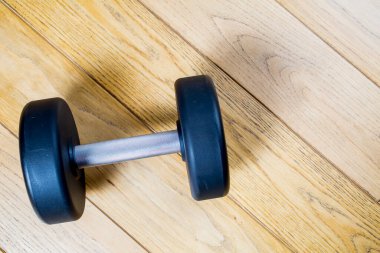 Tahta arka planda siyah lastik ağırlıklar. Ahşap arka planda aptal