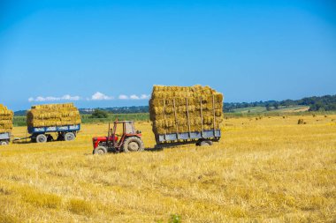 Tarım karavanında saman dolu bir traktör..