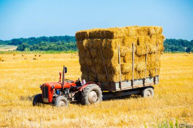 Tarım karavanında saman dolu bir traktör..