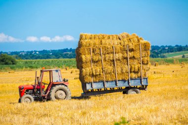 Tarım karavanında saman dolu bir traktör..