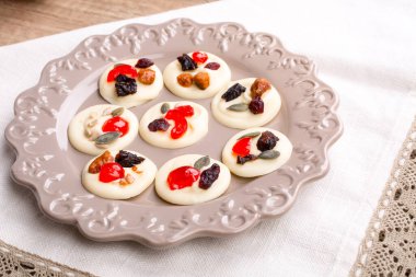 Beyaz çikolatalı kekler, meyveli, fındıklı ve tohumlu ahşap masa.