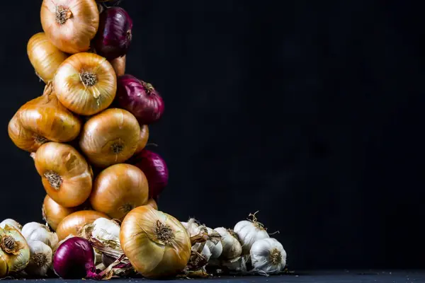 sweet purple Crimean onions, onions and garlic on black background