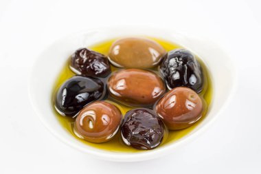 Beyaz arka planda bir kasede zeytinler