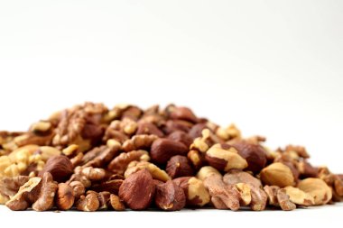 Beyaz arka planda badem, ceviz ve fındık.