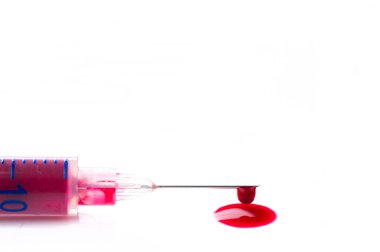 Şırıngada şırıngayla çıkarılmış kan, izole edilmiş beyaz arka planda kan damlaları.