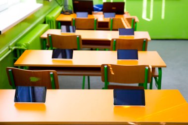 Sınıftaki masalarda dijital tabletler var.