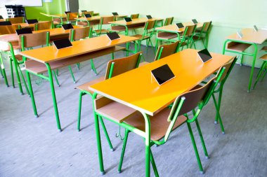 Sınıftaki masalarda dijital tabletler var.