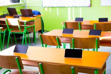 Sınıftaki masalarda dijital tabletler var.