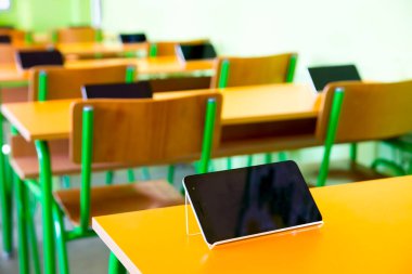 Sınıftaki masalarda dijital tabletler var.