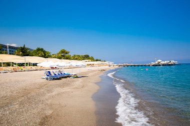 sandy Beach büyük şemsiye altında beyaz plastik şezlong