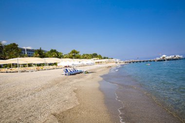 sandy Beach büyük şemsiye altında beyaz plastik şezlong