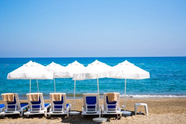 kum plaj şemsiyeleri ve sandalyeler