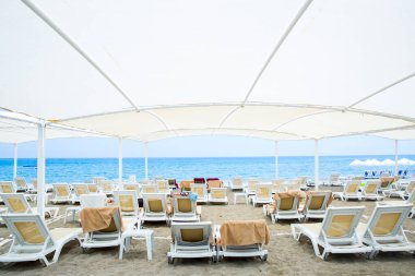 sandy Beach büyük şemsiye altında beyaz plastik şezlong