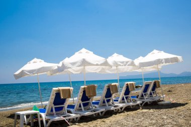 kum plaj şemsiyeleri ve sandalyeler