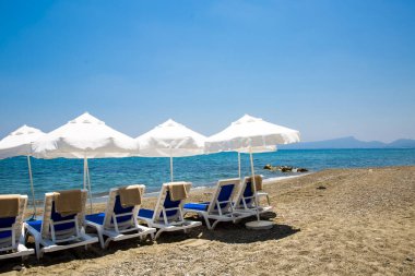 kum plaj şemsiyeleri ve sandalyeler