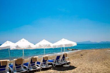 kum plaj şemsiyeleri ve sandalyeler