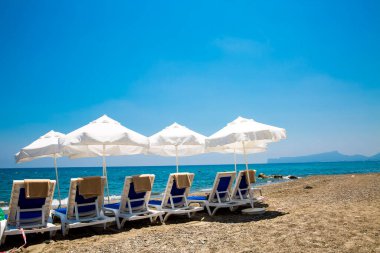 kum plaj şemsiyeleri ve sandalyeler