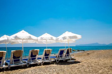 kum plaj şemsiyeleri ve sandalyeler