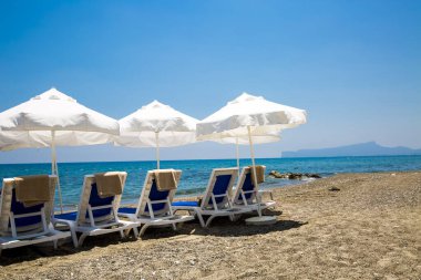 kum plaj şemsiyeleri ve sandalyeler