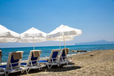 kum plaj şemsiyeleri ve sandalyeler