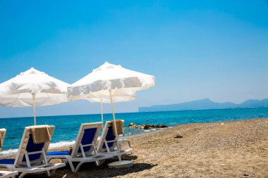 kum plaj şemsiyeleri ve sandalyeler