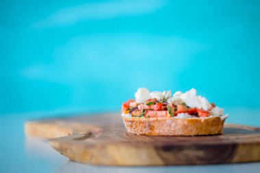 Mavi arka planda domatesli, peynirli ve zeytinyağlı