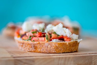 Mavi arka planda domatesli, peynirli ve zeytinyağlı