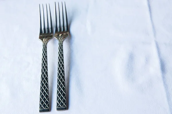 Two meal forks on white background