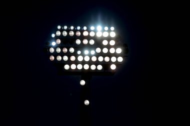 Stadyum ışıkları siyah arkaplanı yansıtıyor